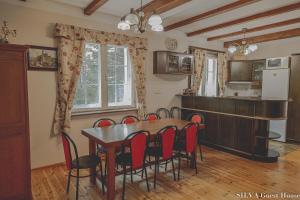 eine Küche und ein Esszimmer mit einem Tisch und Stühlen in der Unterkunft SILVA Guest House - dom wczasowy, tenis, basen, balia i sauna in Borsk