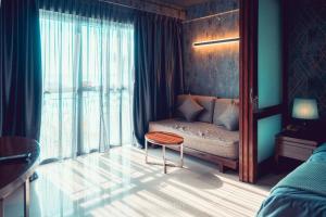 a bedroom with a couch and a table and a window at Seaview Suites at Admiral Bay in Port Dickson +71 photos