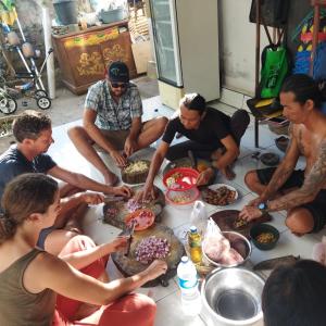 Eine Gruppe von Menschen, die an einem Tisch sitzen und Essen essen. in der Unterkunft Pelangi Beach Homestay in Amed