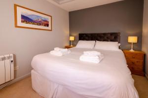 a bedroom with a large white bed with towels on it at Langdale Retreat in Chapel Stile