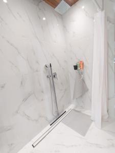 a bathroom with a shower with white marble walls at La Casa in Villaggio Tedeschi