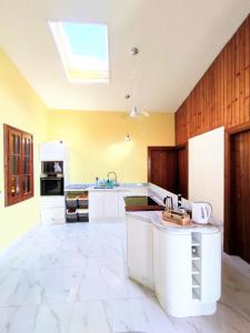 a large kitchen with white cabinets and a skylight at La Casa in Villaggio Tedeschi