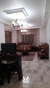 a living room with a table and a couch at Cool Bayader apartment in Amman