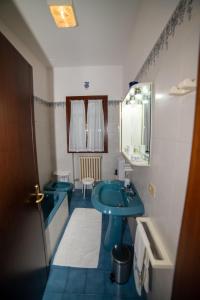 La salle de bains est pourvue d'un lavabo bleu et d'un miroir. dans l'établissement Casa Perugina, à Montagnana