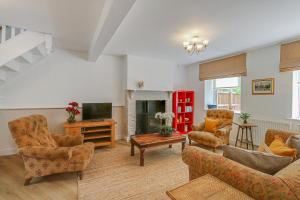 a living room with couches and a tv and a fireplace at Badger Cottage in Parkend
