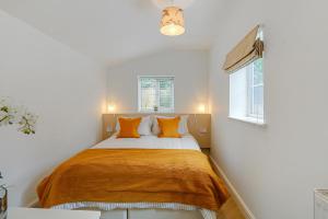 a bedroom with a large bed with orange pillows at Badger Cottage in Parkend