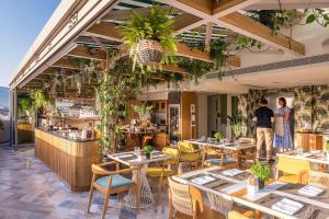 um restaurante com mesas e cadeiras e um bar em Niche Hotel Athens em Atenas