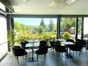 a restaurant with tables and chairs and a large window at Wellness & SPA boutique Hotel pod lipkami Prague in Prague