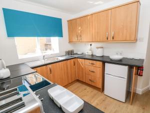 a kitchen with wooden cabinets and a counter top at 3 Mill Wynd in Darlington