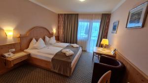 um quarto de hotel com uma cama e uma secretária em Sport und Familienhotel Klausen em Kirchberg in Tirol