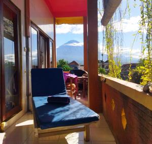 a chair on a balcony with a view of a mountain at Pelangi Beach Homestay in Amed