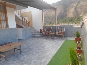 un patio con sillas, mesa y césped en Mini apartamento valle sagrado yucay, en Cusco