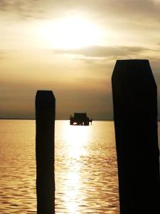 two posts in the water with a boat in the distance at La casa di Alice in Venice