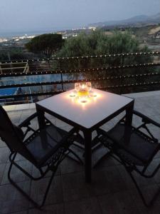 a table and two chairs on a balcony with lights at La Casa in Villaggio Tedeschi