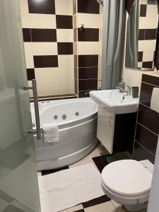 uma casa de banho com uma banheira, um WC e um lavatório. em Tourist Apartment 1 em Piatra Neamţ