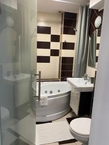 a bathroom with a tub and a toilet and a sink at Tourist Apartment 1 in Piatra Neamţ