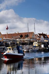 een groep boten is aangemeerd in een haven bij Hotel Siemsens Gaard in Svaneke