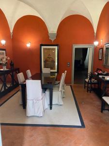 a dining room with orange walls and a table and chairs at Luxury frescoed apartment in the center in Florence