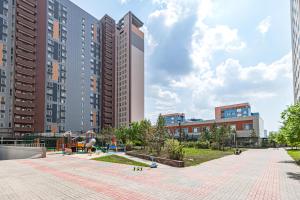 a park in a city with tall buildings at Highvill park apart in Astana