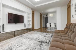 a living room with a flat screen tv on a wall at Highvill park apart in Astana