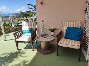2 Stühle und ein Tisch auf der Terrasse in der Unterkunft VILLA PANORAMICA & IDROMASSAGGIO 008031-LT-0055 in Imperia