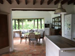 Una cocina con una mesa y sillas en una cocina. en La Cour Martin à 7 km d'Etretat-Gîte classé 3 étoiles, en Cuverville