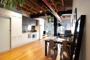 cocina y comedor con mesa y sillas en New York Style Warehouse Loft by Sydney Dreams, en Sídney