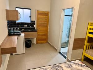 cocina con encimera, fregadero y puerta en Marmeu Tombo, en Guarujá