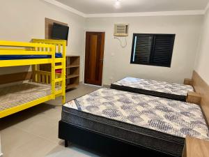 1 dormitorio con 2 literas y TV en Marmeu Tombo, en Guarujá