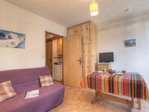 a living room with a purple couch and a television at Charmant studio à Chantemerle, Serre-Chevalier pour 2 pers, parking et casier à ski inclus - FR-1-330E-67 in Saint-Chaffrey