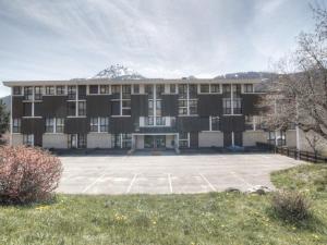 a large building with a parking lot in front of it at Appartement Saint-Chaffrey , 1 pièce, 2 personnes - FR-1-330E-66 in Saint-Chaffrey
