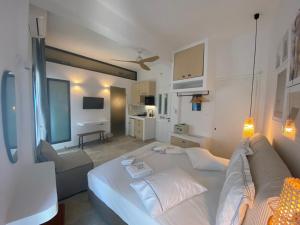 ein Schlafzimmer mit einem großen Bett und einem Sofa in der Unterkunft Kores of Poros in Poros
