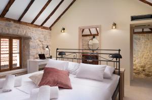 ein Schlafzimmer mit einem großen weißen Bett mit weißen Kissen in der Unterkunft Dvor Pitve Villas in Jelsa