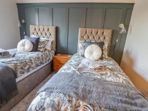 a bedroom with two beds with pillows on them at Rhif Saith in Ruthin