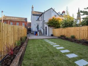 a backyard with a fence and a grass yard at Rhif Saith in Ruthin