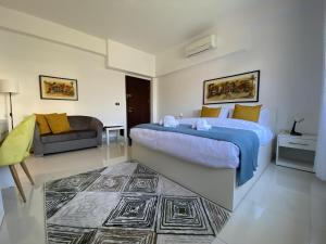 Lemon Tree Residence في عمّان: غرفة نوم مع سرير مزدوج كبير وأريكة