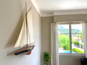 a model boat hanging on a wall next to a window at Villa Soleil d'Or in Villefranche-sur-Mer