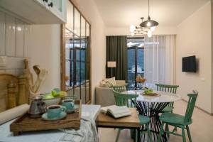 a living room with a table and green chairs at RIS Holiday Apartments Tsaghkadzor in Tsaghkadzor