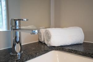 a bathroom sink with a faucet and a towel at The Inn South Stainley in Harrogate