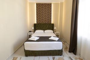 a bedroom with a bed with a green headboard at Modern Revival Luxury Hotel in Thessaloniki