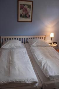 Una cama con dos almohadas blancas encima. en Bauernhof FeWo X Pferdekoppel in Schwienkuhl an der Ostsee, en Schwienkuhl