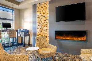 a lobby with a fireplace with a tv and chairs at Quality Inn & Suites in Petawawa