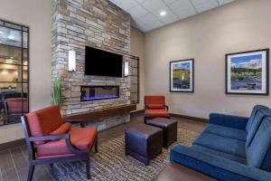 ein Wartezimmer mit einem Sofa und Stühlen sowie einem TV in der Unterkunft Comfort Inn Butte City Center I-15 - I-90 in Butte