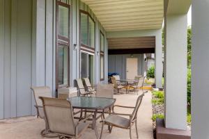 a patio with tables and chairs on a building at Clarion Pointe Tomah in Tomah