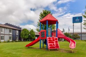 a playground with a slide in a yard at Clarion Pointe Tomah in Tomah