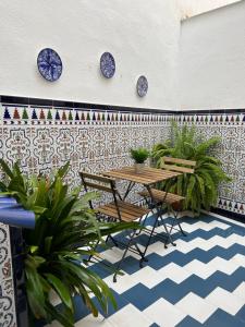 d'une terrasse avec une table, des chaises et des plaques bleues sur un mur. dans l'établissement Las Parras House - Casa en Torredelcampo, à Torre del Campo
