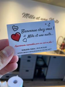 a person holding up a card with a heart on it at Mille et une nuit, appartement classé 3 étoiles en RDC avec exterieur et parking in Dole