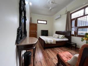 um quarto com uma cama e uma secretária num quarto em Param Country Home With Pool em Jalandhar