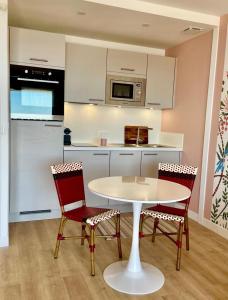 a kitchen with a white table and two chairs at Large studio direct access to the beach in Pornichet