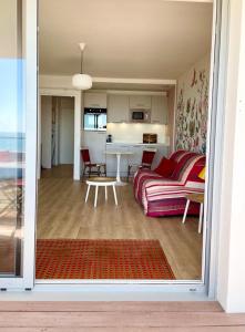 een woonkamer en een keuken met een bank en een tafel bij Large studio direct access to the beach in Pornichet